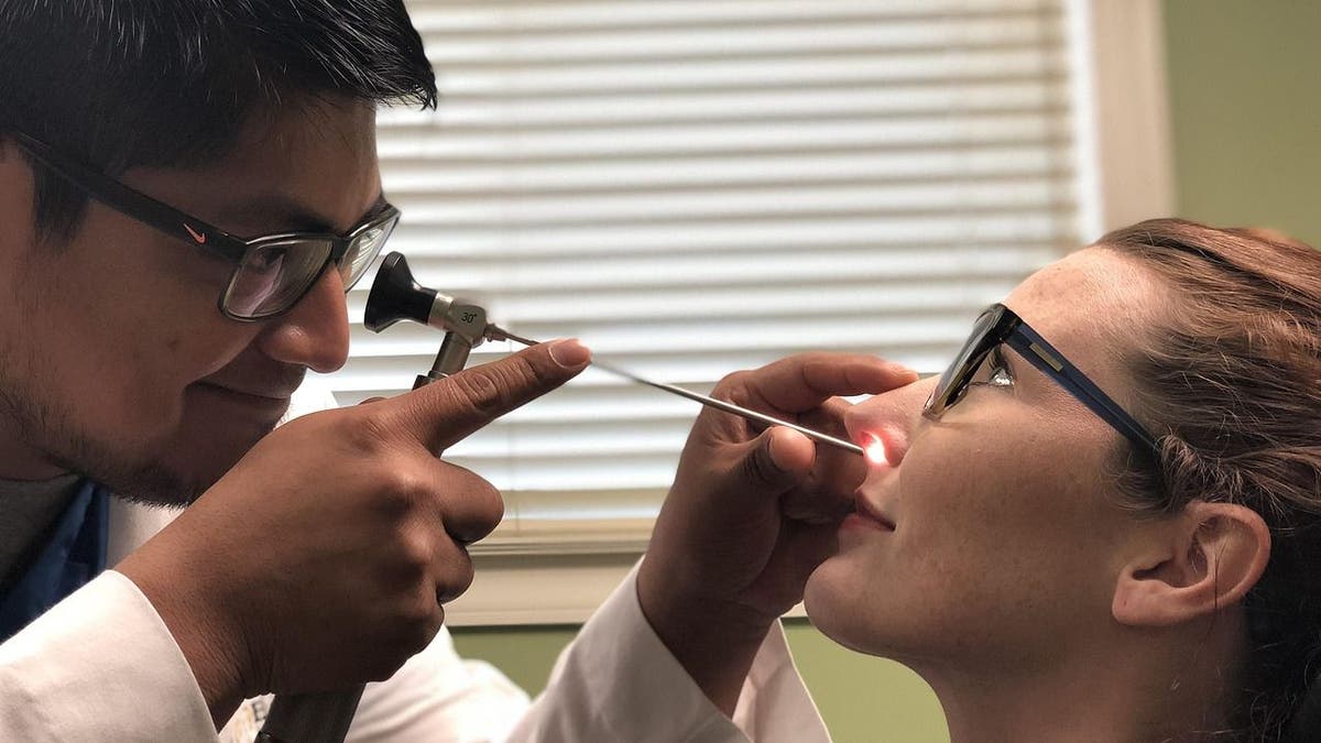 How micro-robots may soon treat your sinus infections 4 A doctor examining a woman with a sinus infection.