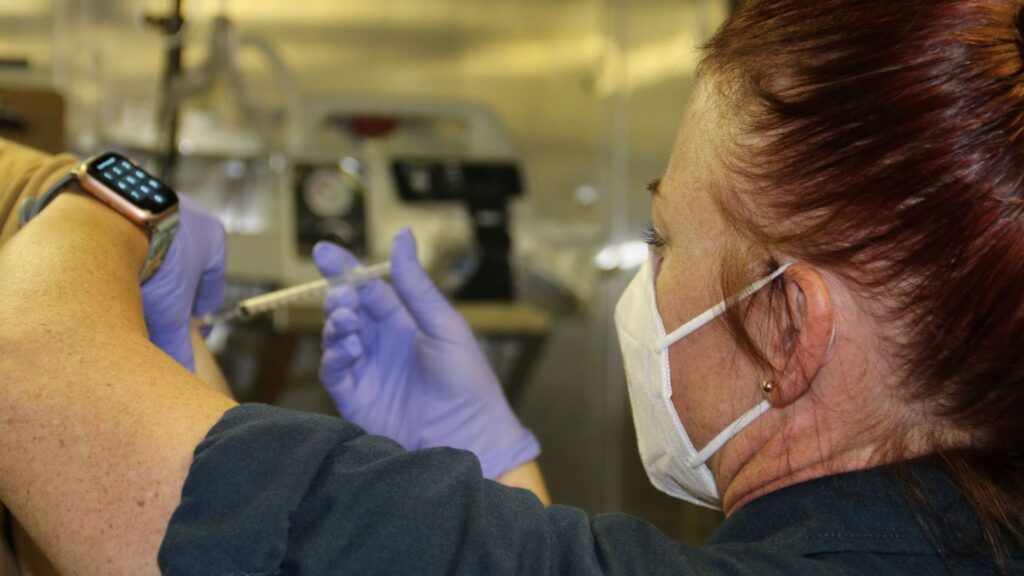 a sailor receive COVID 19 booster shot